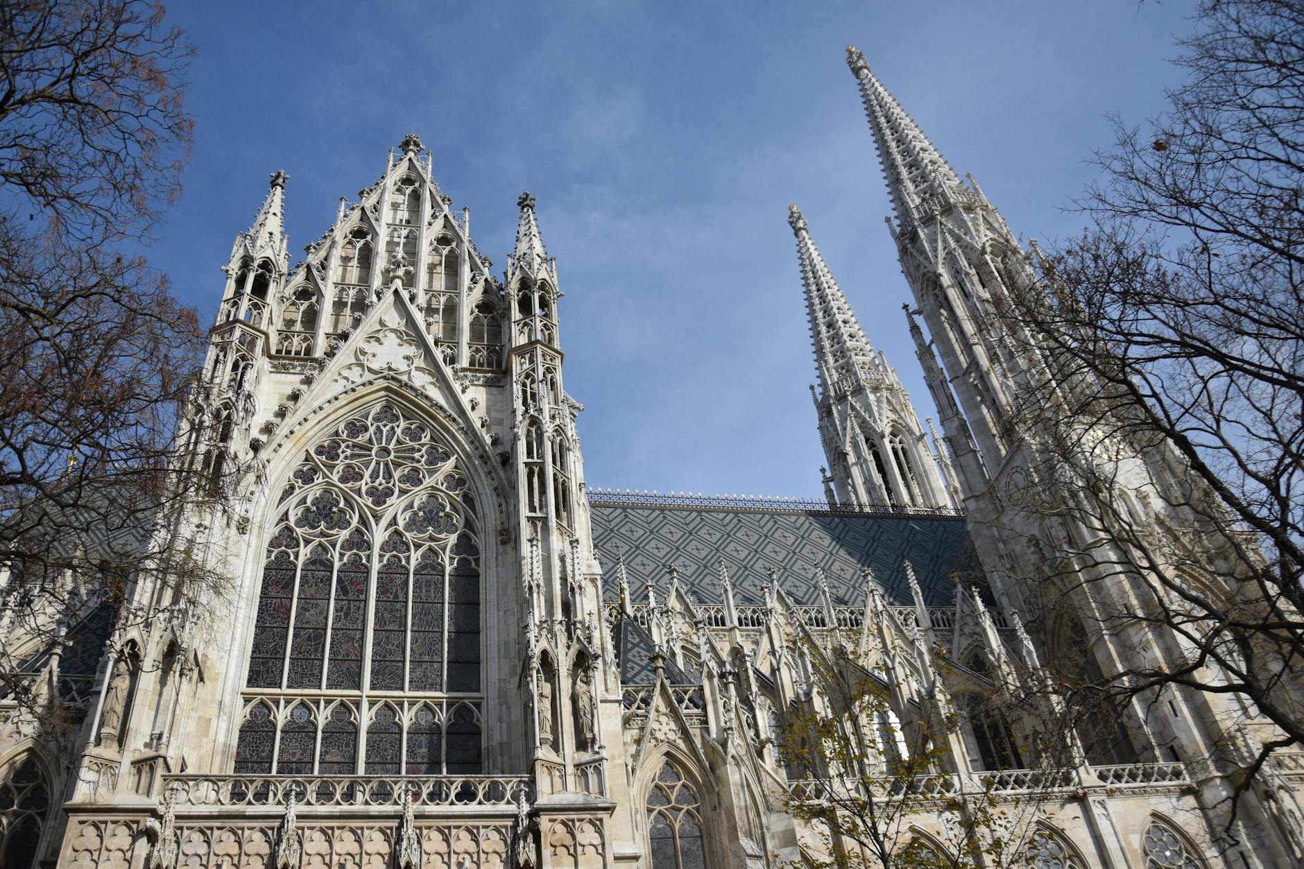 Impressive Gothic architecture of Votive Church in Vienna under clear blue sky.