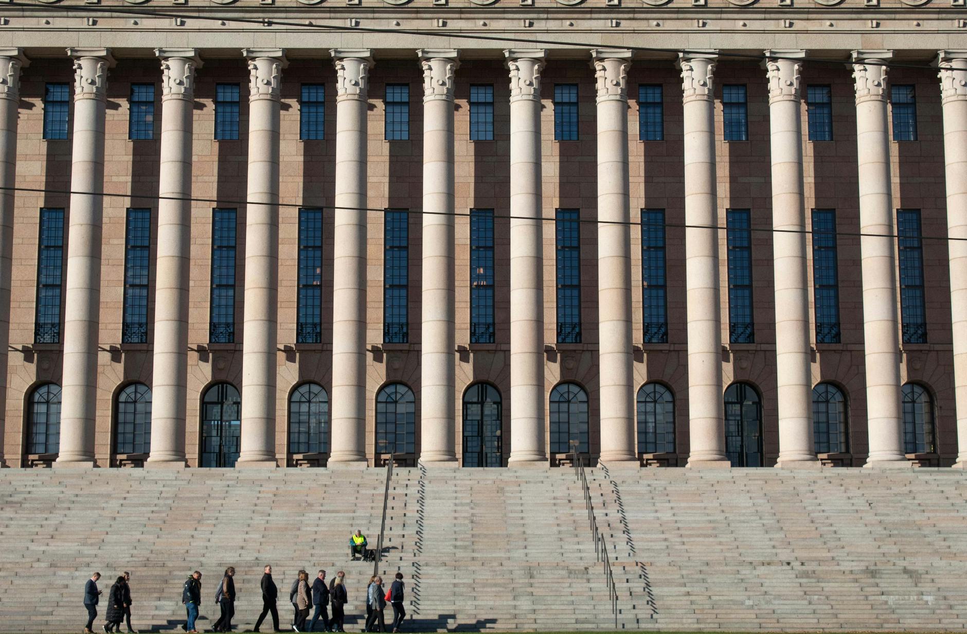 View of the Finnish Parliament House showcasing its grand neoclassical architecture with prominent colonnades.