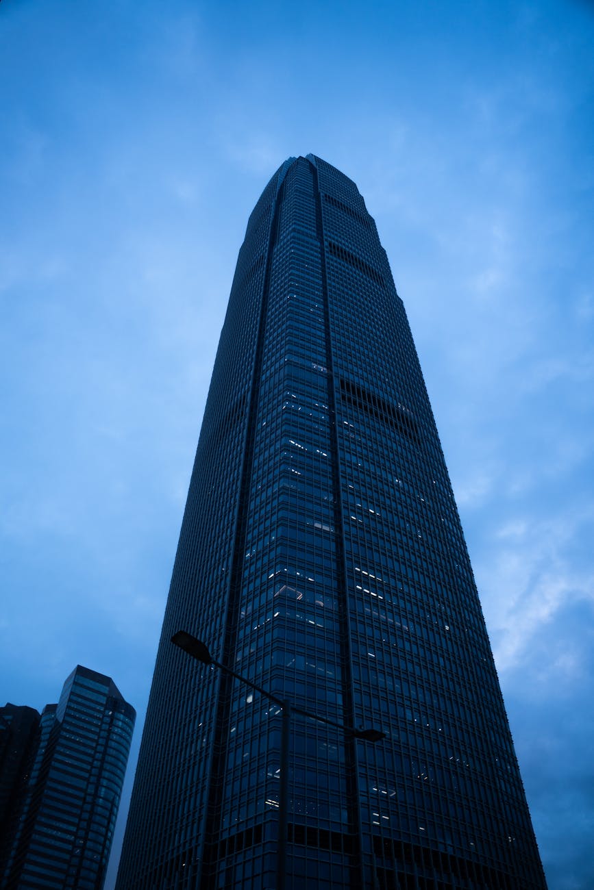Dramatic view of a Hong Kong skyscraper against a moody dusk sky, showcasing modern architecture.