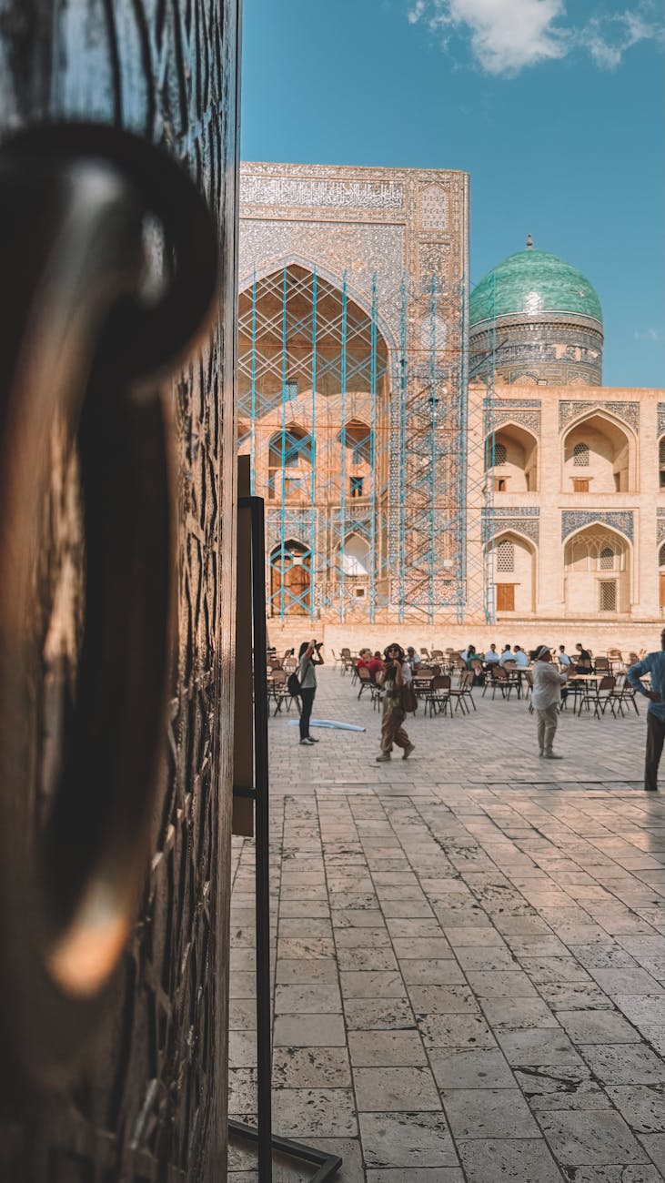 Vibrant photo of Bukhara's mosque courtyard, with iconic turquoise dome and rich architecture, capturing cultural essence.
