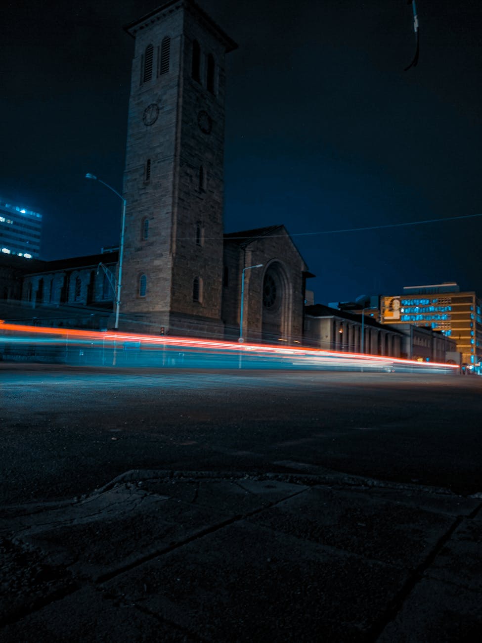 Dramatic night view of Harare cityscape featuring light trails and a historic tower.